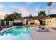Lush backyard with a shimmering pool and jacuzzi, and views into the open layout of the home at 1609 W State Ave, Phoenix, AZ 85021