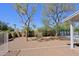 Expansive backyard with trees, gravel, and landscaping and a white fence at 16256 N 64Th Pl, Scottsdale, AZ 85254
