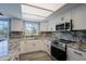 Bright kitchen features granite countertops, stainless steel appliances, white cabinets, and natural light at 16256 N 64Th Pl, Scottsdale, AZ 85254