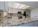 Contemporary kitchen boasting granite countertops, white cabinets, and stainless steel appliances at 16256 N 64Th Pl, Scottsdale, AZ 85254