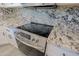 Stainless steel stove and range in a remodeled kitchen with granite countertops and white cabinets at 16256 N 64Th Pl, Scottsdale, AZ 85254