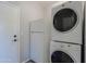 Compact laundry room includes stacked washer/dryer and a white refrigerator for added convenience at 16256 N 64Th Pl, Scottsdale, AZ 85254