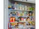 Walk-in pantry with shelving stocked with food and containers offers kitchen storage and organization at 16256 N 64Th Pl, Scottsdale, AZ 85254