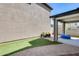 A backyard featuring a covered patio, hardscape, and artificial turf for easy maintenance at 16562 W Sierra St, Surprise, AZ 85388