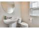 Clean half bathroom featuring a pedestal sink, toilet, and window for natural light at 16562 W Sierra St, Surprise, AZ 85388