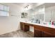 Bright bathroom featuring double sinks, modern fixtures, and wood-look flooring at 16562 W Sierra St, Surprise, AZ 85388