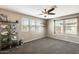 Spacious carpeted bedroom with a ceiling fan, multiple windows, and football helmet display at 16562 W Sierra St, Surprise, AZ 85388