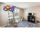 Cozy bedroom with two windows, shelving, and storage space for toys at 16562 W Sierra St, Surprise, AZ 85388