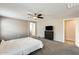 Carpeted bedroom with modern ceiling fan and TV above dark dresser, perfect for relaxation at 16562 W Sierra St, Surprise, AZ 85388