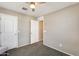 A neutral bedroom features carpet, a ceiling fan and two doors at 16562 W Sierra St, Surprise, AZ 85388