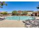 A refreshing community pool is surrounded by lounge chairs and lush landscaping at 16562 W Sierra St, Surprise, AZ 85388