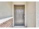 A close-up of a gray front door with a stone accent wall on one side at 16562 W Sierra St, Surprise, AZ 85388
