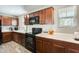 Close-up view of kitchen with black appliances, dark wood cabinets, and ample counter space at 16562 W Sierra St, Surprise, AZ 85388