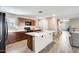 Well-lit kitchen featuring an island, modern appliances, wooden cabinets, and wood-look tile flooring at 16562 W Sierra St, Surprise, AZ 85388