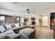 Open concept living area with a large sectional sofa, ceiling fan, and wood-look tile flooring at 16562 W Sierra St, Surprise, AZ 85388