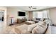 Spacious living room featuring a large sectional sofa, ceiling fan, and entertainment center at 16562 W Sierra St, Surprise, AZ 85388