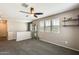 Carpeted loft space with a ceiling fan, three windows, and football helmet display at 16562 W Sierra St, Surprise, AZ 85388