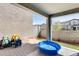 Covered patio with a hardscape and an adjacent artificial grass play area at 16562 W Sierra St, Surprise, AZ 85388
