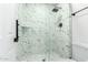 This modern walk-in shower is tiled with black and white marbled tiles and stylish fixtures at 17411 N 36Th St, Phoenix, AZ 85032