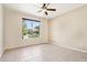 Bedroom featuring tile floors, a ceiling fan, and a large window with a view of the backyard at 18013 N Sterling Dr, Surprise, AZ 85374