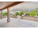 A covered patio area offers a relaxing outdoor space with stone columns, pergola, and desert landscape views at 18013 N Sterling Dr, Surprise, AZ 85374