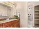 Well-lit bathroom with granite countertop, stylish vanity, and a shower with decorative tile accents at 1837 E Presidio Rd, Phoenix, AZ 85022