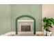 Cozy fireplace with a decorative hearth, complemented by green accent wall at 1837 E Presidio Rd, Phoenix, AZ 85022
