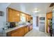 Functional kitchen with stainless steel sink, wooden cabinetry, and standard appliances at 1849 E Jarvis Ave, Mesa, AZ 85204