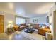 Bright living room featuring a large leather couch, area rug and plenty of natural light at 1849 E Jarvis Ave, Mesa, AZ 85204