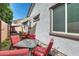 Backyard patio with red chairs, a glass table and shaded seating area against house exterior at 20017 S 192Nd Pl, Queen Creek, AZ 85142