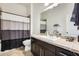 A well-lit bathroom with a wide mirror, dark cabinets, and a shower-tub combination, perfect for relaxing at 20017 S 192Nd Pl, Queen Creek, AZ 85142