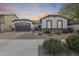 Charming single-story home with a well-manicured yard, desert landscaping, and a two-car garage at sunset at 20017 S 192Nd Pl, Queen Creek, AZ 85142