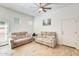Bright living room featuring neutral walls, wood tile floors, and cozy seating with a ceiling fan at 20017 S 192Nd Pl, Queen Creek, AZ 85142