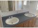 Bathroom with double sinks, wood cabinets, and a large mirror for convenience at 2028 E Libby St, Phoenix, AZ 85022
