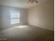Spacious bedroom with neutral carpet, ceiling fan, and window offering natural light at 2028 E Libby St, Phoenix, AZ 85022