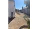 Side yard with gravel ground and mature trees, providing shade and privacy at 2028 E Libby St, Phoenix, AZ 85022