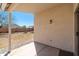 A covered back patio with brick base, overlooking the yard and clear blue sky at 2031 S 86Th Ln, Tolleson, AZ 85353