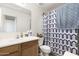 Cozy bathroom featuring a wooden vanity, white sink, and modern geometric shower curtain at 2031 S 86Th Ln, Tolleson, AZ 85353