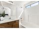 Well-lit bathroom with a large mirror, white tiled shower, and coordinated vanity at 2031 S 86Th Ln, Tolleson, AZ 85353