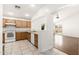 Bright kitchen featuring wooden cabinets, white appliances, tile floors, and access to the backyard at 2031 S 86Th Ln, Tolleson, AZ 85353