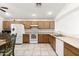 Spacious kitchen featuring white appliances, wooden cabinets, tile floors, and ample counter space at 2031 S 86Th Ln, Tolleson, AZ 85353