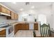 Bright kitchen featuring wooden cabinets, white appliances, tile floors, and a passthrough to the living room at 2031 S 86Th Ln, Tolleson, AZ 85353