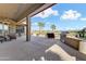 Inviting back patio with built-in grill, comfortable lounge chairs, and serene views of the well-manicured landscaping at 20609 N Canyon Whisper Dr, Surprise, AZ 85387