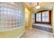 Relaxing bathroom showcasing a glass block wall, soaking tub, and private access at 20609 N Canyon Whisper Dr, Surprise, AZ 85387
