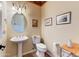 Powder room with pedestal sink, wainscoting, decorative mirror, and tiled floors at 20609 N Canyon Whisper Dr, Surprise, AZ 85387