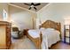 This cozy bedroom features a detailed wood bed frame, soft natural light, and a ceiling fan at 20609 N Canyon Whisper Dr, Surprise, AZ 85387
