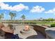 Cozy outdoor fire pit area with comfortable seating and views of lush greenery and a bright blue sky at 20609 N Canyon Whisper Dr, Surprise, AZ 85387