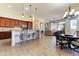 Open concept kitchen with wood cabinets, tile backsplash, and center island with seating overlooking the dining area and living room at 20609 N Canyon Whisper Dr, Surprise, AZ 85387