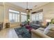 Sunlit living room boasting large windows, a ceiling fan, and comfortable seating for relaxing and entertaining at 20609 N Canyon Whisper Dr, Surprise, AZ 85387