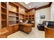 Well-lit office boasts custom built-in shelving, a large desk, and comfortable seating at 20609 N Canyon Whisper Dr, Surprise, AZ 85387